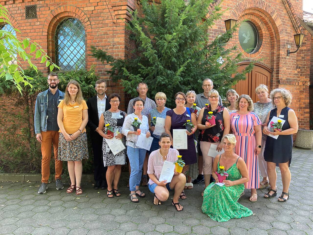 14 neue ehrenamtliche Hospizbegleiter der Pfeifferschen Stiftungen und ihre Koordinatoren stehen vor der Samariterkirche